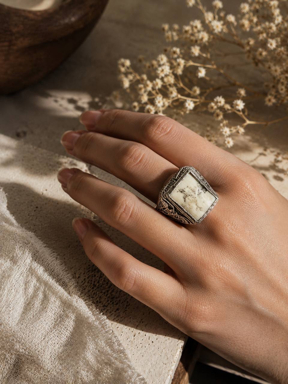 Featuring intricate silver detailing and a stunning natural white real stone